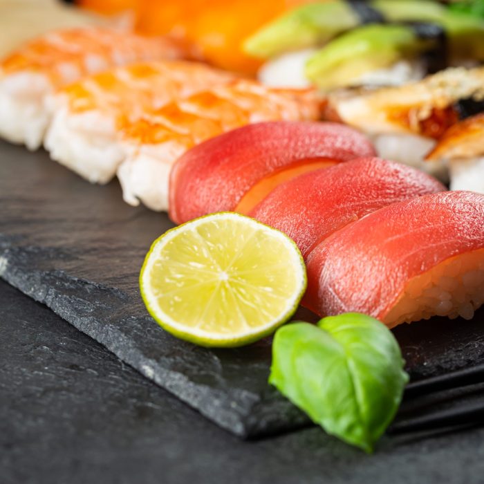 Set of sushi and maki with soy sauce over black background. Top view with copy space